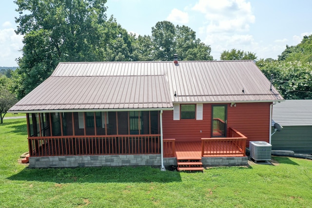 rear view of property with a lawn, a deck, and central AC