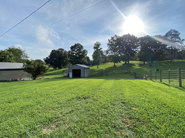 view of yard with a rural view and a storage shed