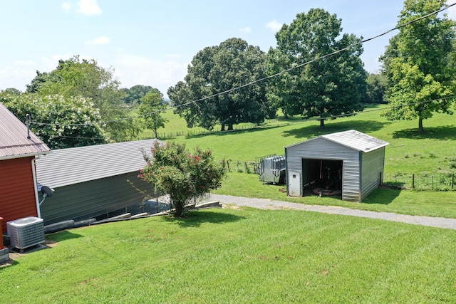 view of yard with central AC unit and a storage shed