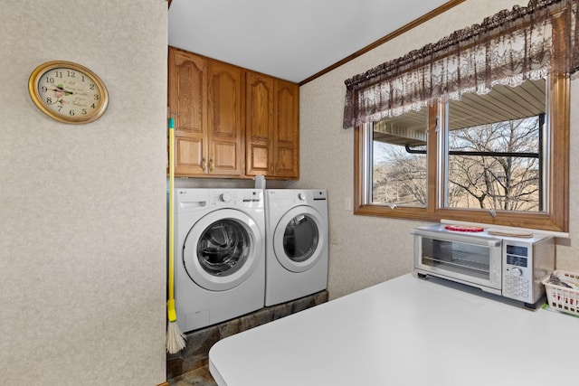 clothes washing area with cabinets, ornamental molding, and washing machine and clothes dryer