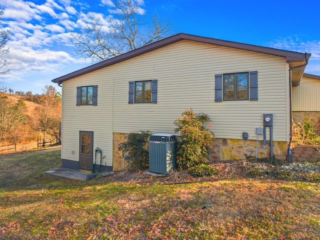 view of home's exterior featuring central AC unit and a yard