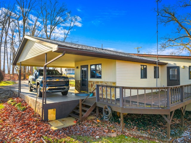 rear view of property featuring a wooden deck and a carport