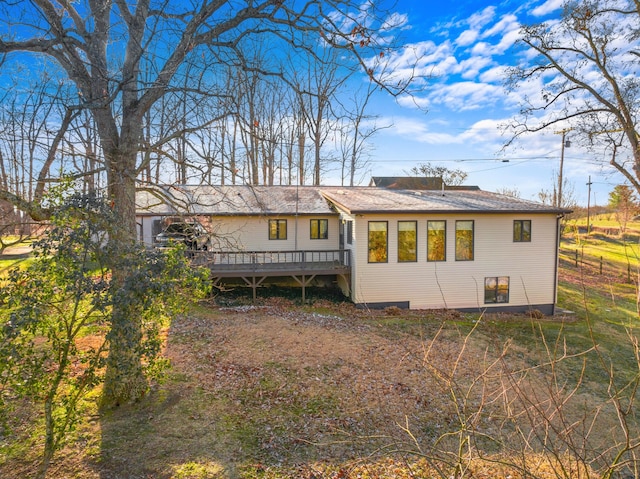 rear view of house featuring a wooden deck