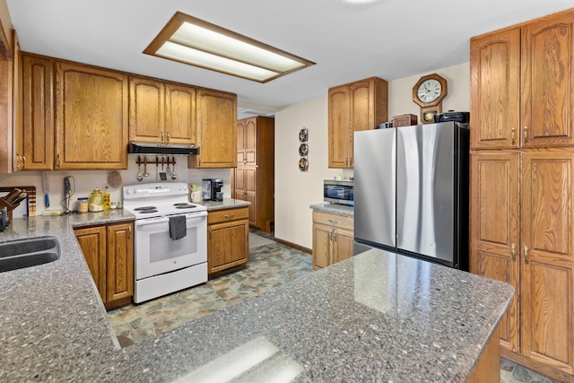 kitchen featuring stainless steel appliances, dark stone counters, and sink