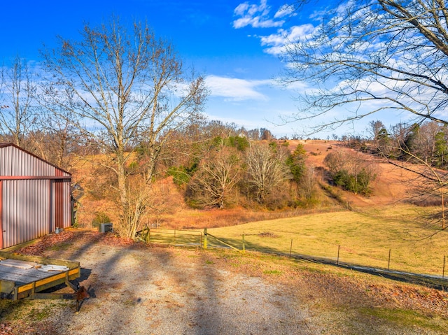 view of yard with a rural view and an outdoor structure