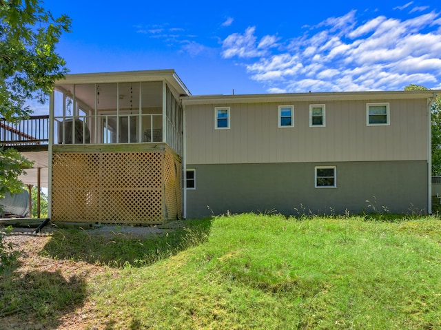 back of house with a sunroom and a yard