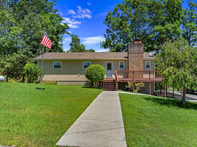 view of front of home with a chimney, a deck, and a front lawn