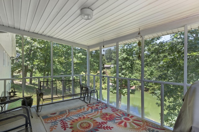 sunroom featuring a water view and a healthy amount of sunlight