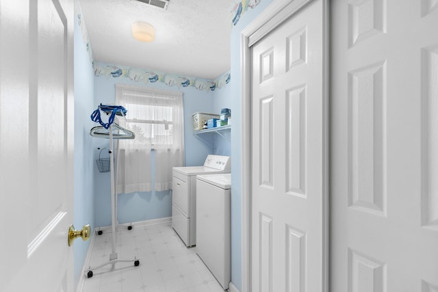 laundry room with laundry area, baseboards, a textured ceiling, light floors, and separate washer and dryer