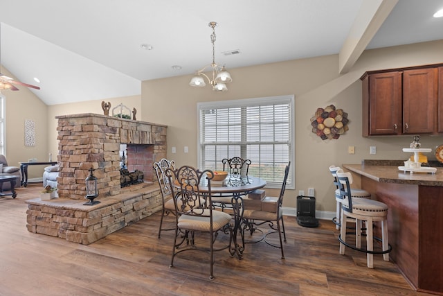 dining area with ceiling fan with notable chandelier and dark hardwood / wood-style floors