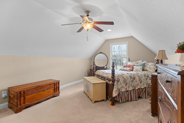 bedroom featuring lofted ceiling, ceiling fan, light carpet, and a textured ceiling