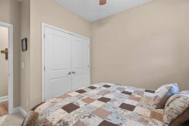 carpeted bedroom featuring a closet and ceiling fan