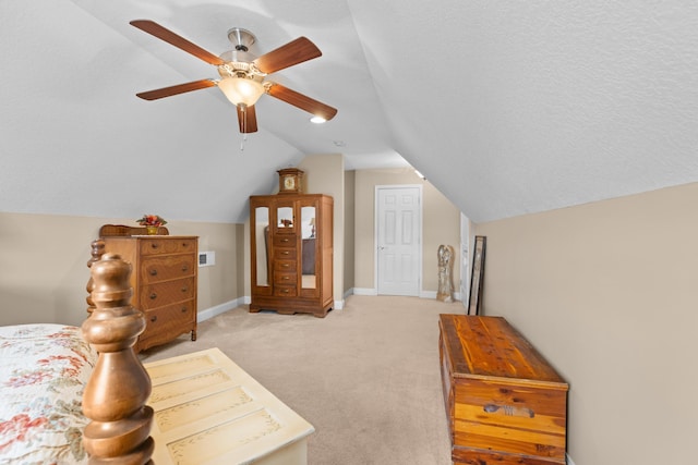 carpeted bedroom featuring ceiling fan, lofted ceiling, and a textured ceiling