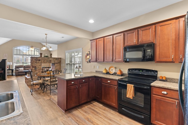 kitchen featuring pendant lighting, black appliances, stone countertops, light hardwood / wood-style floors, and kitchen peninsula