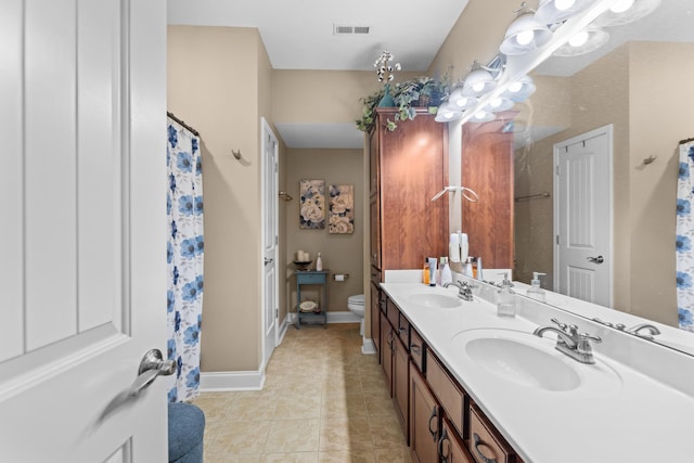 bathroom featuring tile patterned flooring, vanity, and toilet