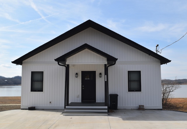 view of front of house with a patio and a water view