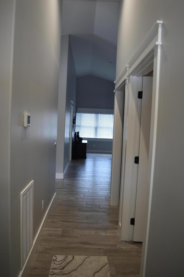 hall featuring vaulted ceiling and dark wood-type flooring