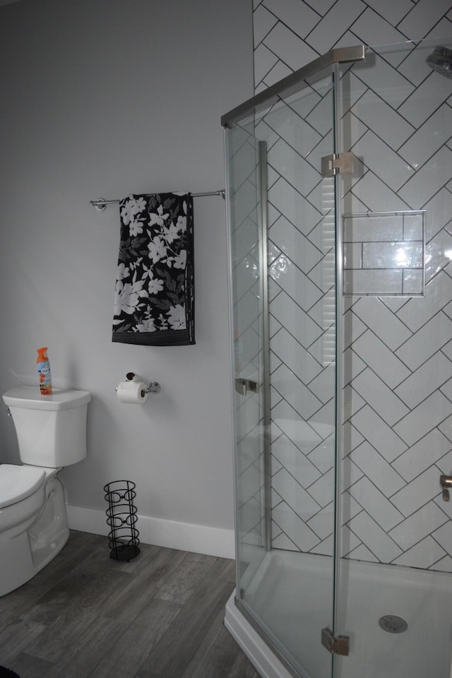 bathroom featuring hardwood / wood-style flooring, toilet, and walk in shower