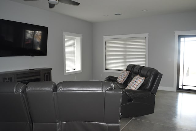 living room featuring ceiling fan and concrete flooring