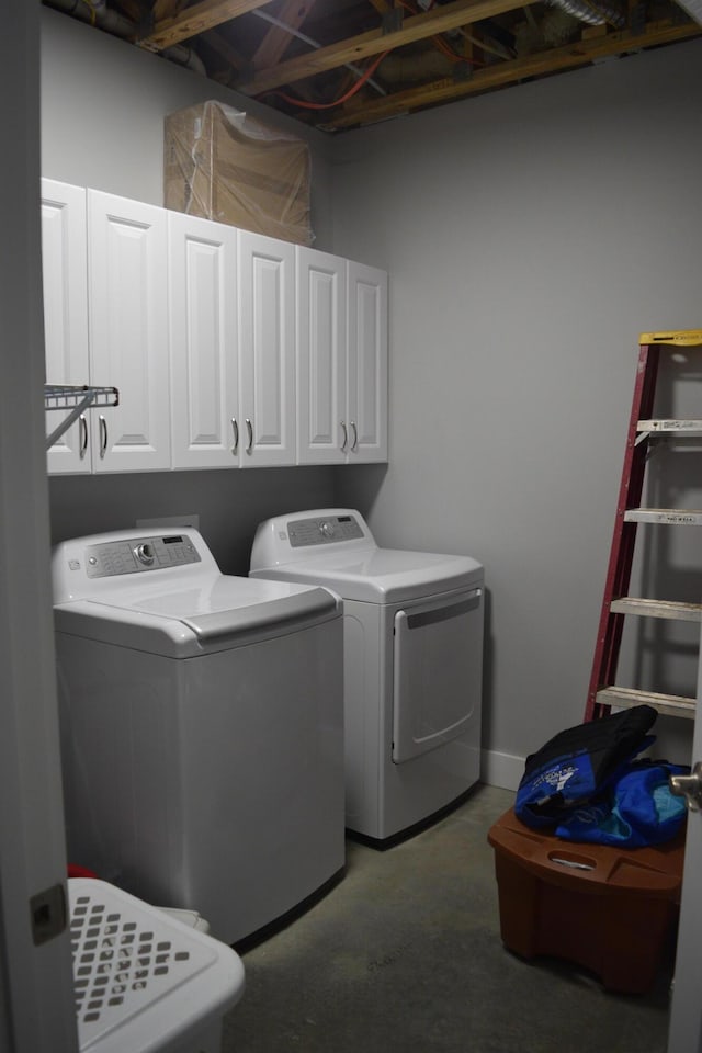 laundry area with washer and clothes dryer and cabinets