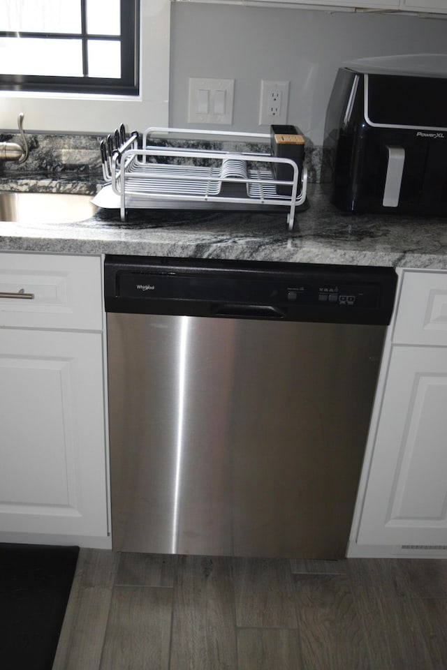 kitchen with stainless steel dishwasher and white cabinets