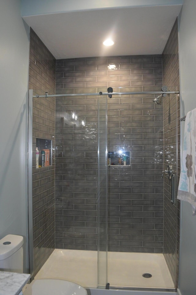 bathroom featuring walk in shower and toilet