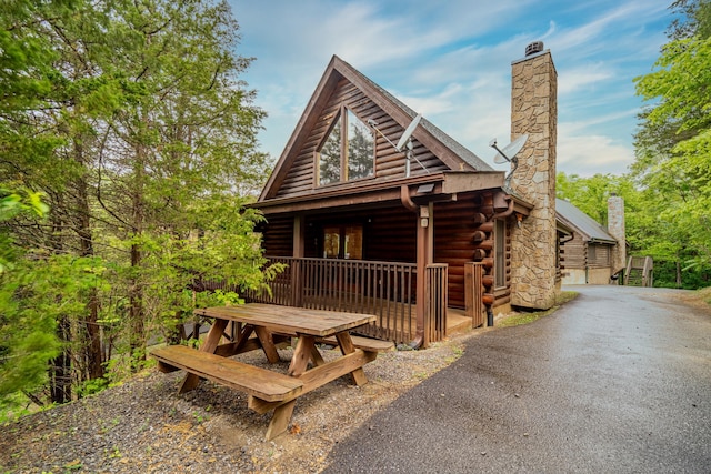log-style house with log exterior and a chimney