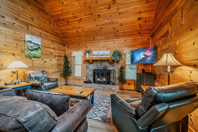 living room featuring high vaulted ceiling, wooden walls, a fireplace, light hardwood / wood-style floors, and wood ceiling