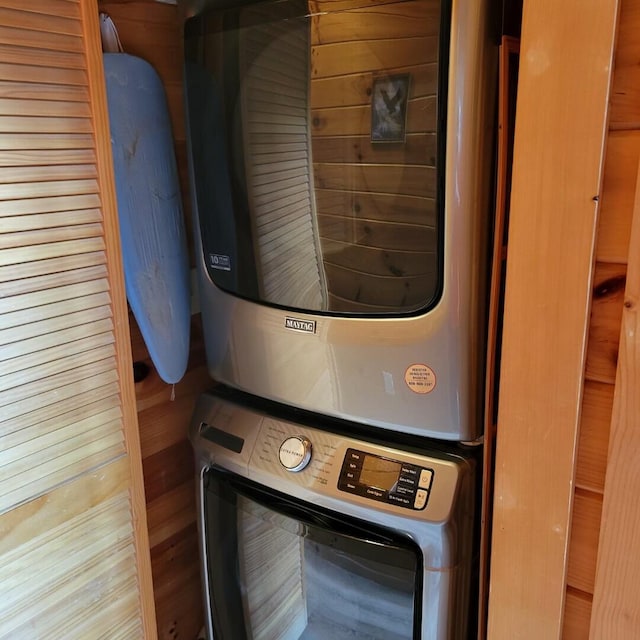 washroom featuring stacked washer and clothes dryer