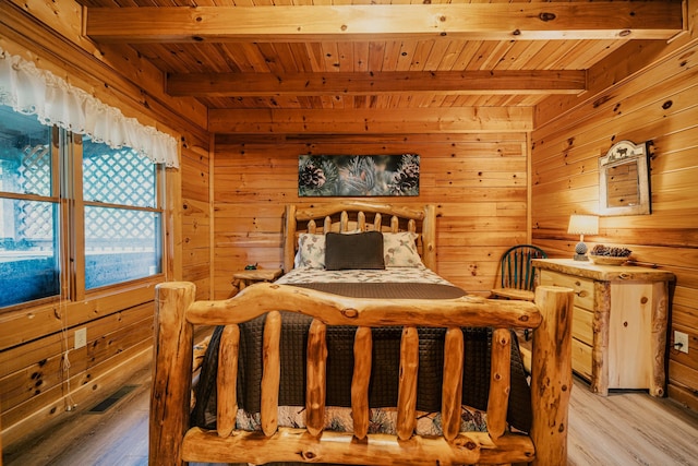 bedroom featuring beamed ceiling, light wood-type flooring, wooden walls, and wooden ceiling