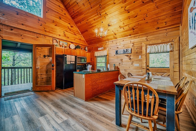 kitchen featuring plenty of natural light, black fridge, high vaulted ceiling, and light hardwood / wood-style flooring