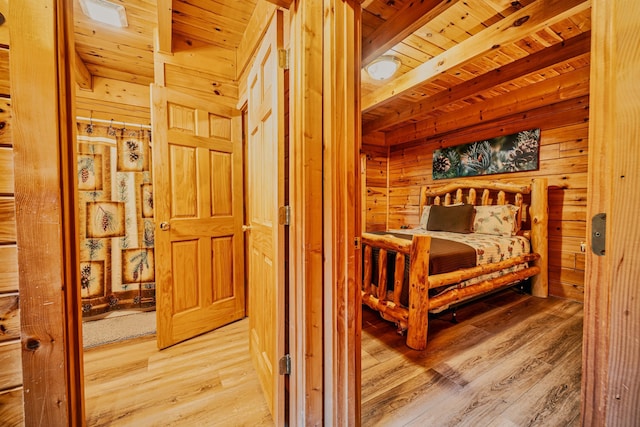 bedroom with beam ceiling, wood walls, wooden ceiling, and hardwood / wood-style flooring