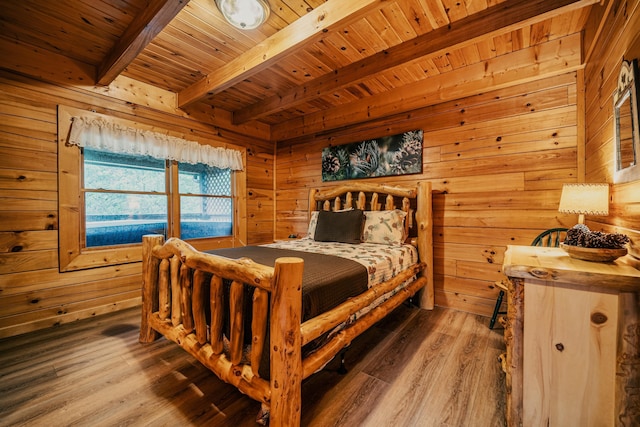 bedroom with beam ceiling, wooden walls, hardwood / wood-style floors, and wood ceiling