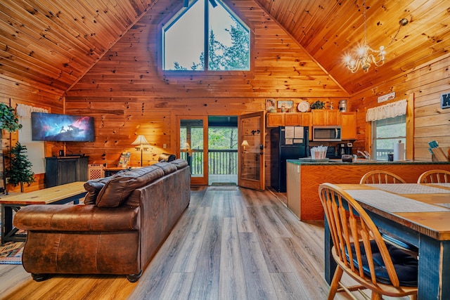 living room with wood walls, light hardwood / wood-style floors, wooden ceiling, and high vaulted ceiling