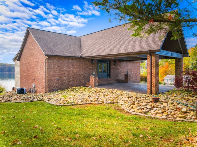 rear view of house featuring a lawn, a patio area, and french doors