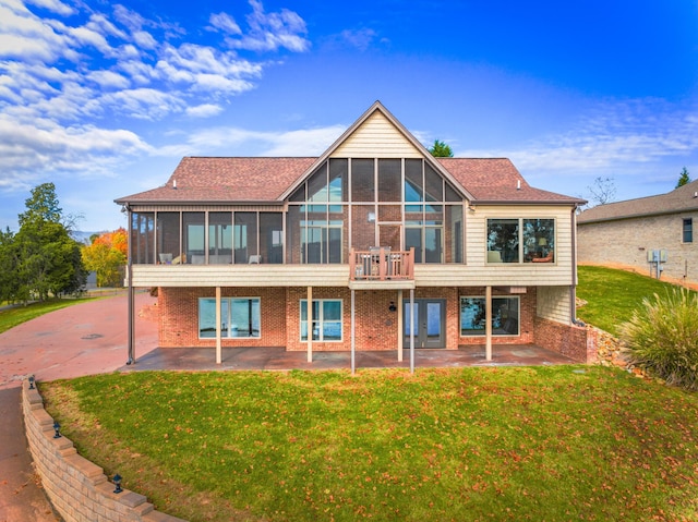 back of property featuring a sunroom, a yard, and a patio