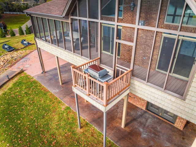 exterior space with a sunroom, grilling area, and a lawn