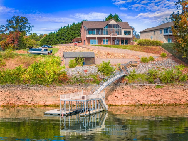 rear view of property featuring a water view and a balcony