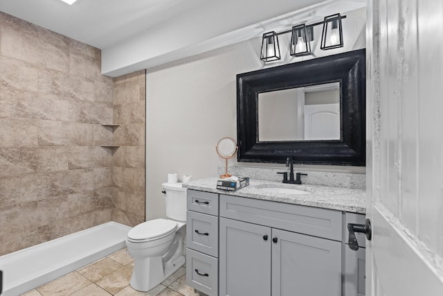 bathroom with tile patterned floors, vanity, toilet, and a shower