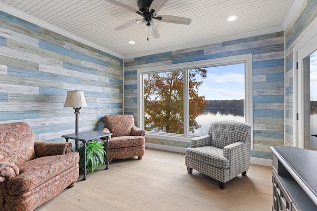 living area featuring ceiling fan, a water view, crown molding, and light hardwood / wood-style flooring