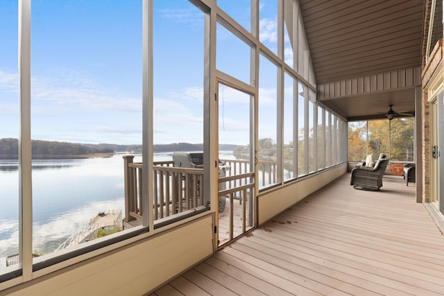 unfurnished sunroom featuring a water view and ceiling fan