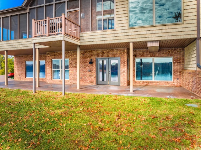 back of property featuring french doors, a balcony, and a patio area