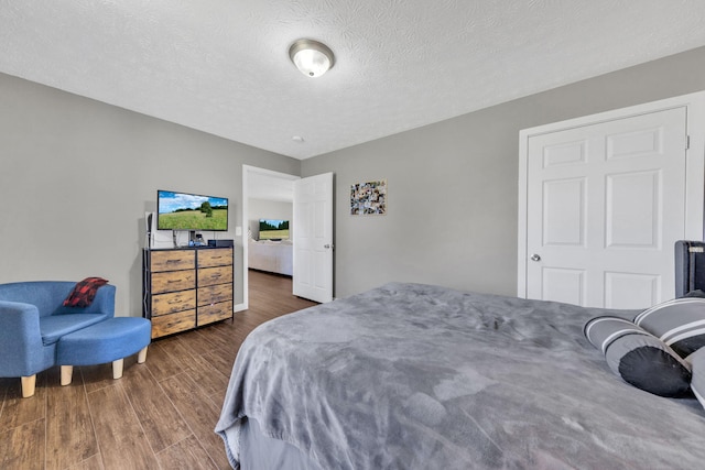 bedroom with a textured ceiling and wood finished floors