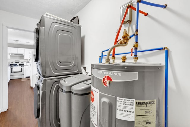 washroom featuring stacked washer and clothes dryer, electric water heater, a textured ceiling, wood finished floors, and laundry area