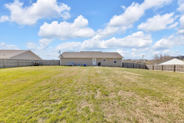 back of property with a lawn and a fenced backyard