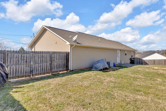 exterior space featuring a yard, central AC unit, roof with shingles, and fence