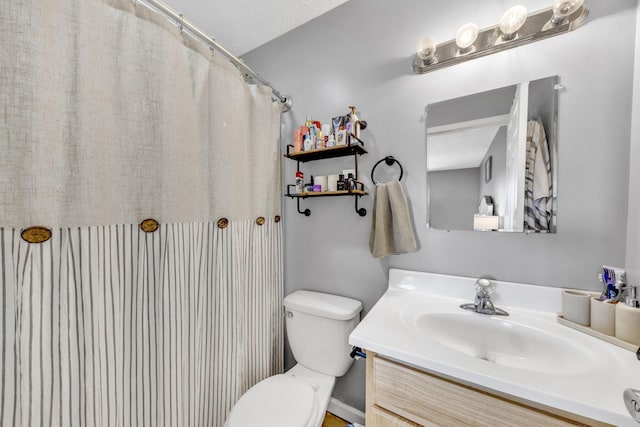 bathroom featuring curtained shower, vanity, and toilet