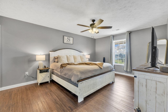 bedroom with a textured ceiling, dark wood-type flooring, a ceiling fan, visible vents, and baseboards