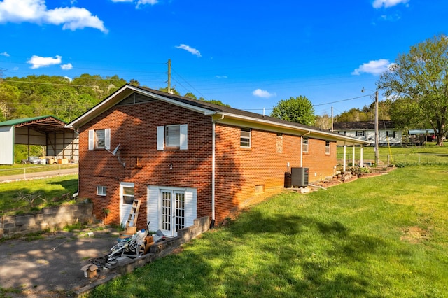 2757 Bethel Rd, Morristown, TN 37813 - back of house featuring brick siding, a detached carport, a lawn, central AC unit, and french doors