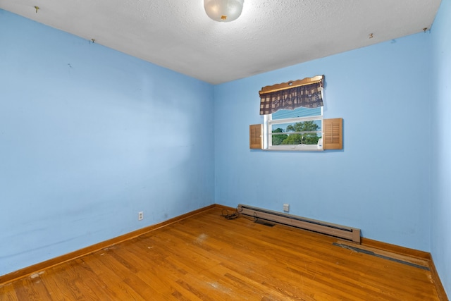 2757 Bethel Rd, Morristown, TN 37813 - spare room with a baseboard radiator, wood finished floors, baseboards, and a textured ceiling
